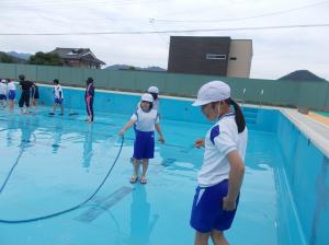ホースで水をまいて、ごみを流します。