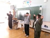 弓道チームがゴムで弓の弾き方を説明しています。